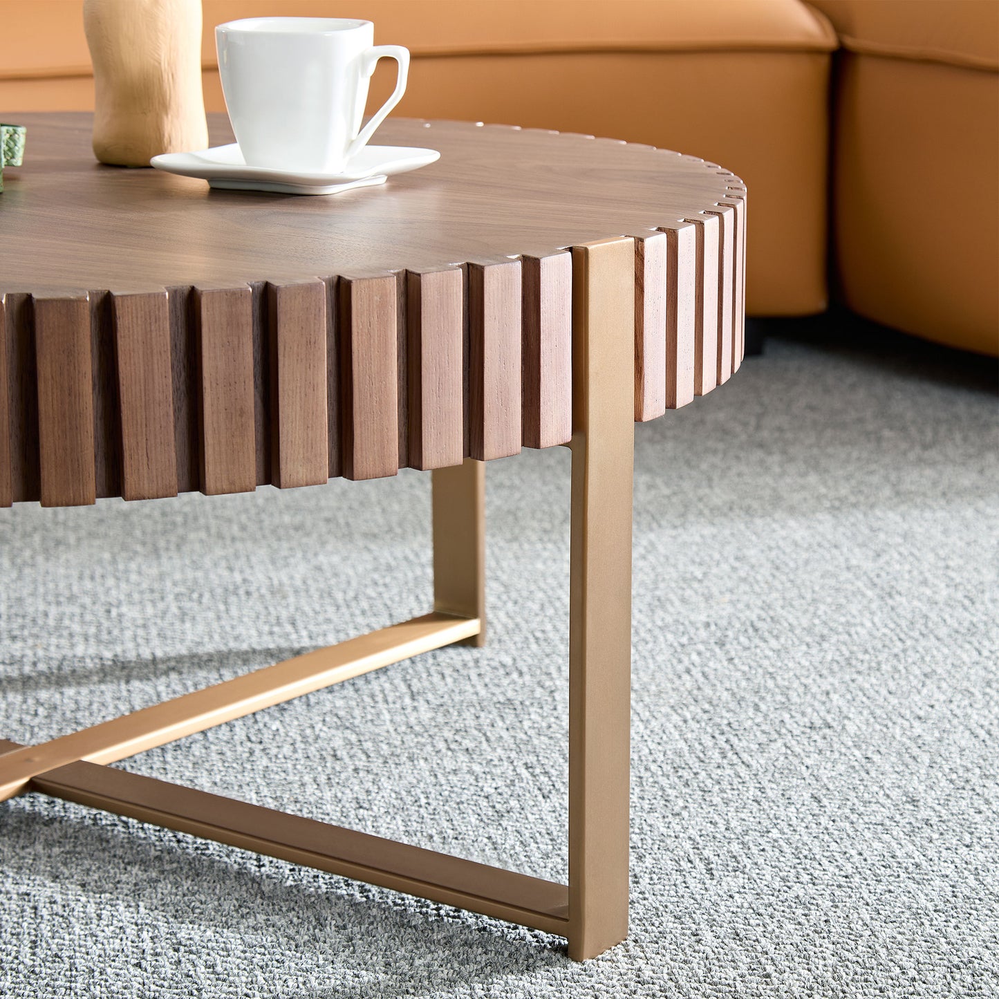 Round walnut coffee table with fluted wood detail and gold metal legs on a grey carpet