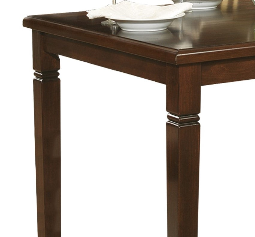 Dark wood dining table corner with detailed leg