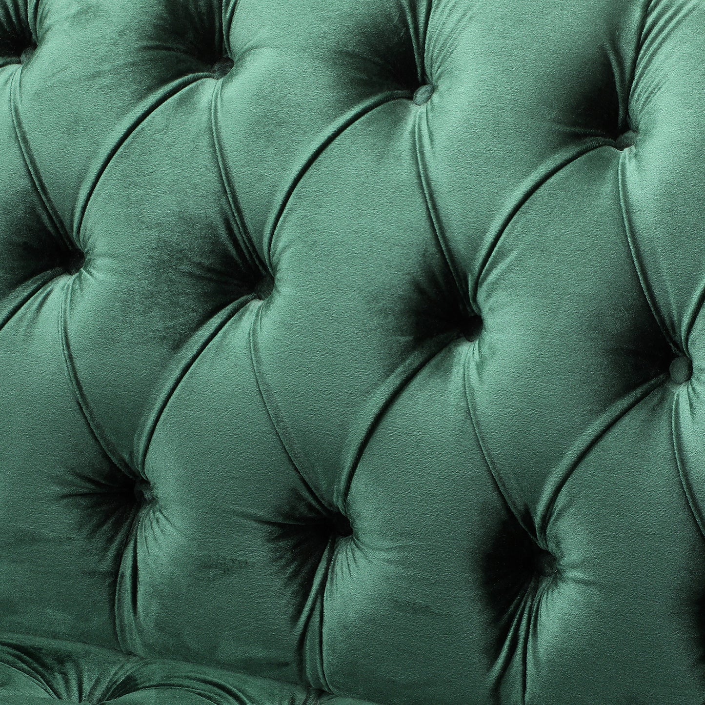 Closeup of deep emerald green velvet tufted fabric upholstery for a luxurious sofa