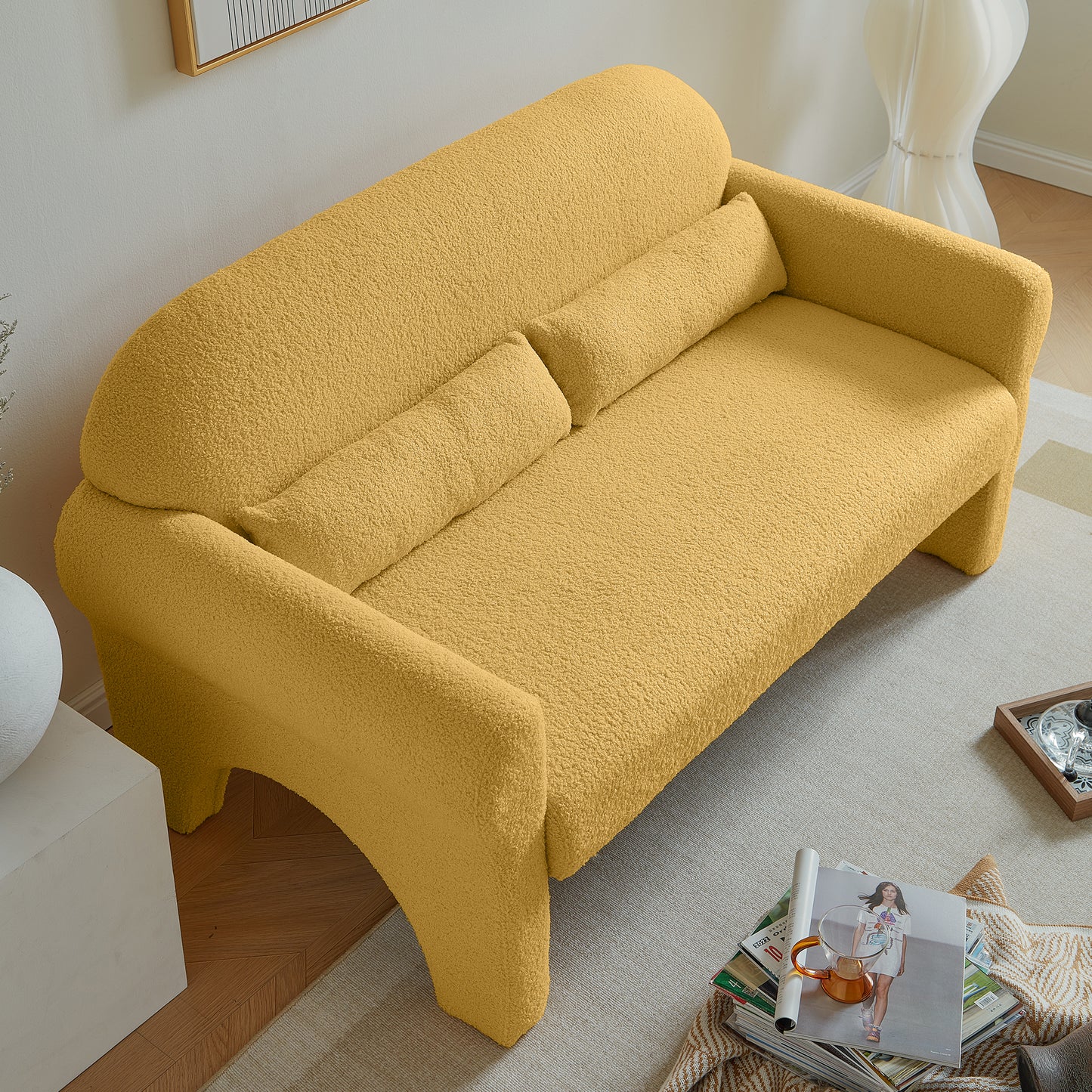 Textured yellow boucl fabric sofa with curved arms and bolster pillows