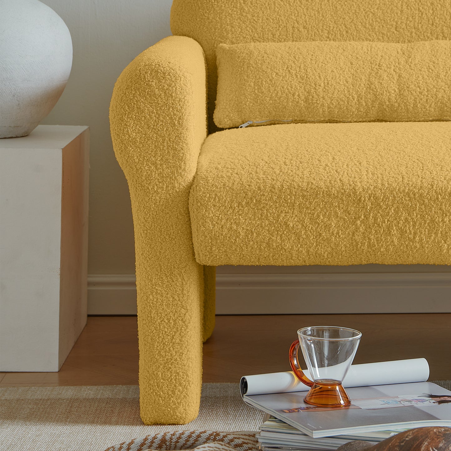 Textured yellow boucle armchair armrest with a lumbar pillow
