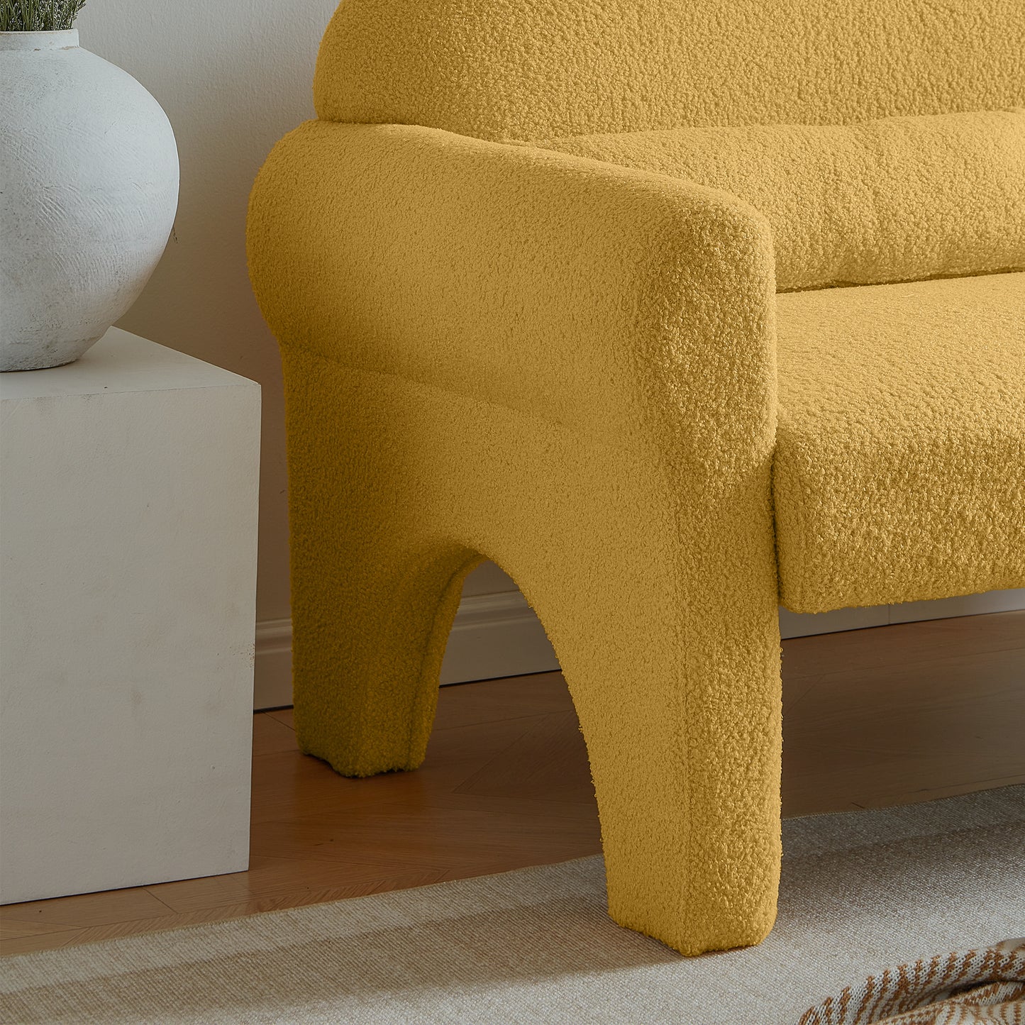Mustard yellow boucle armchair with curved armrest and unique leg design characters