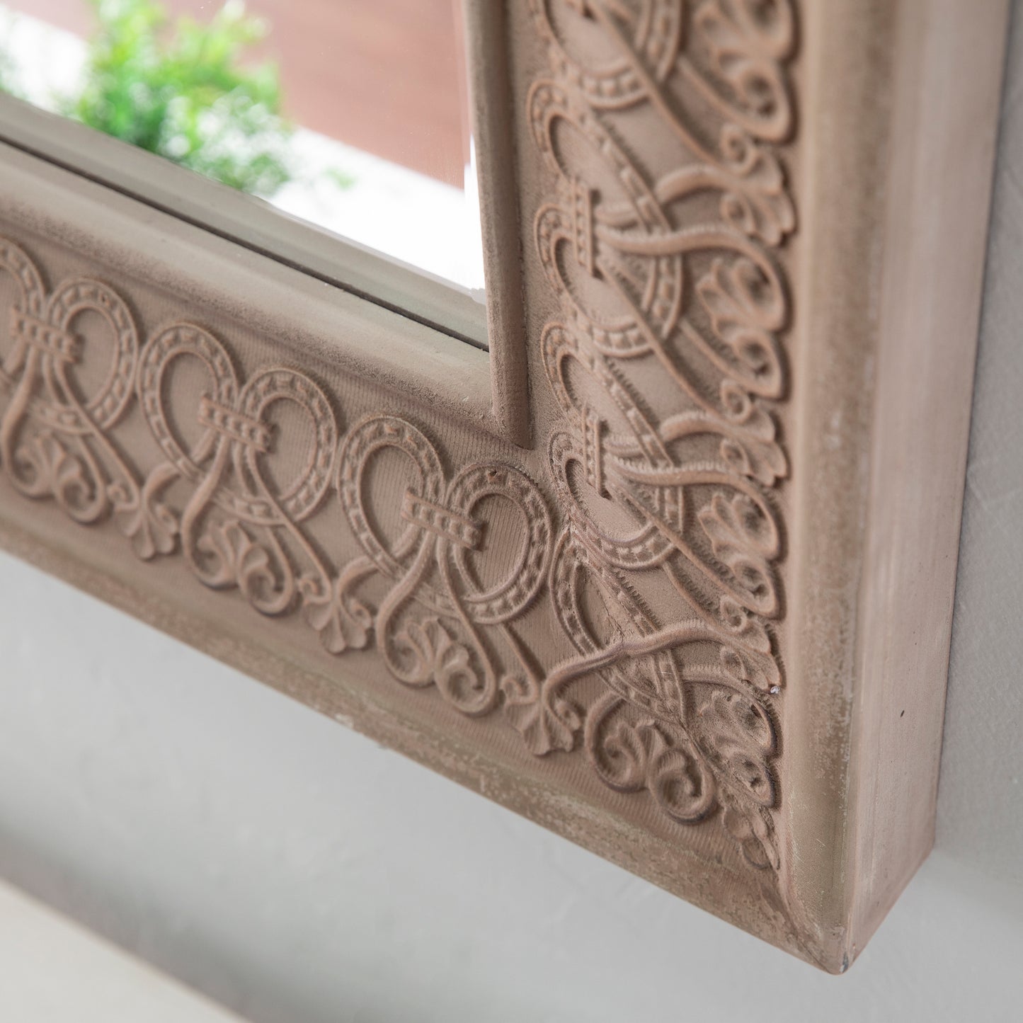 Ornate beige mirror frame with intricate scrolling details elegant home decor