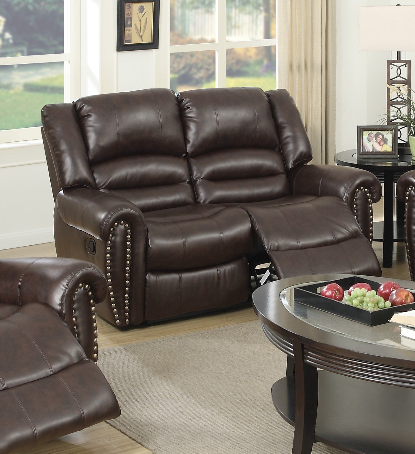 Brown leather reclining loveseat with nailhead trim providing comfortable seating