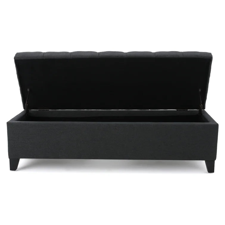 Dark grey upholstered storage ottoman with tufted lid open revealing black interior