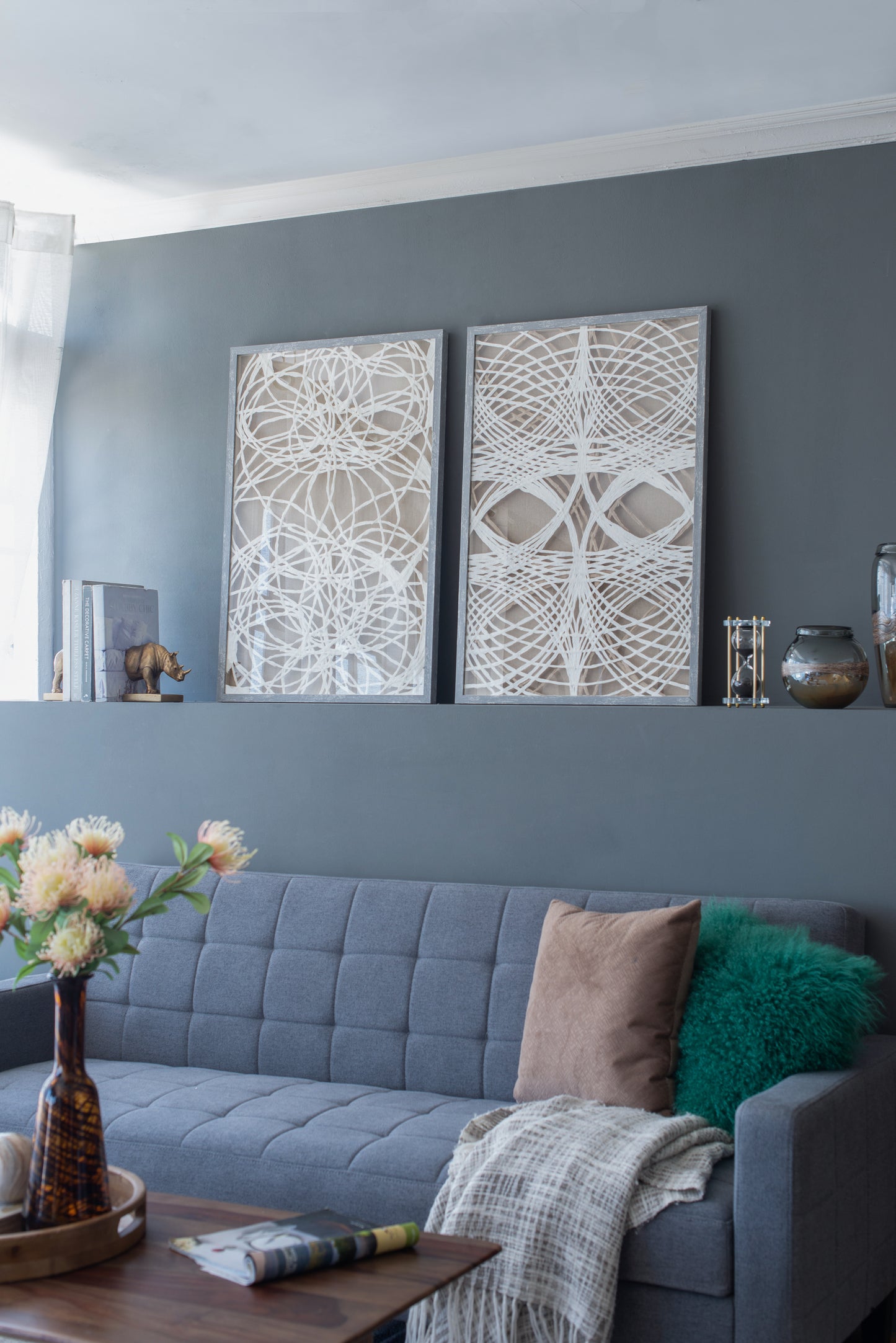 Gray tufted fabric sofa with two decorative pillows and a throw blanket perfect for living rooms