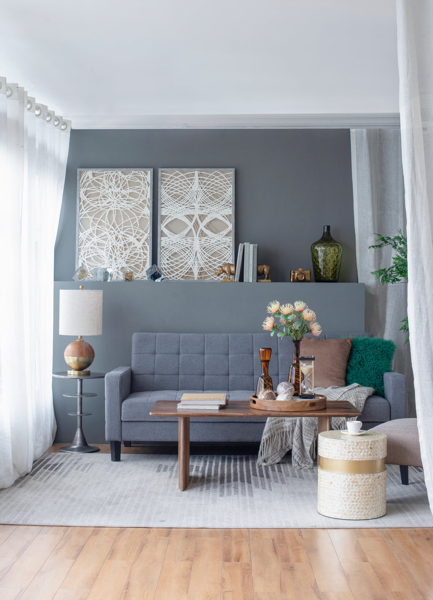 Tufted grey linen sofa with decorative pillows and throw blanket