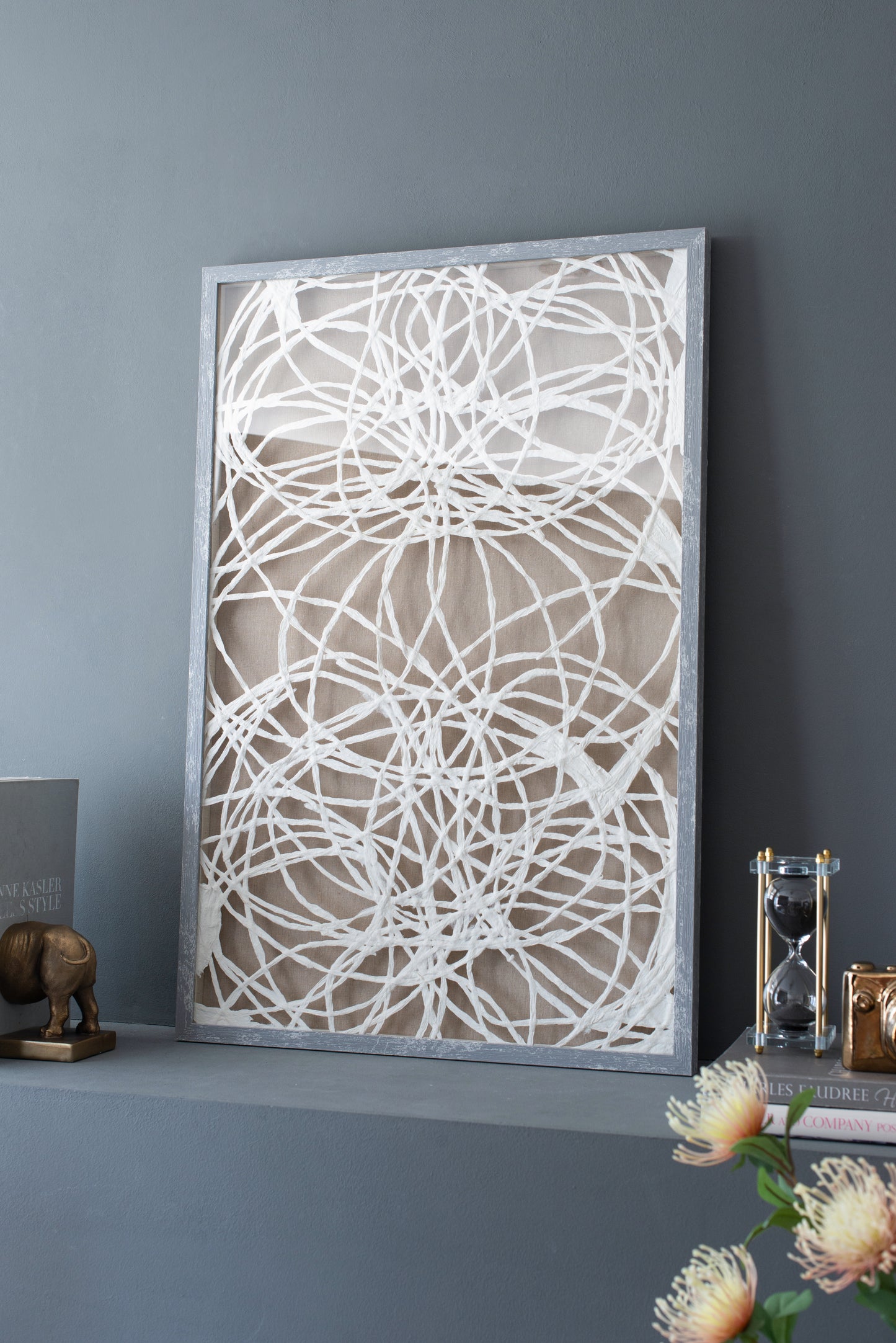 White abstract thread art in a distressed grey frame textured beige background for modern wall decor