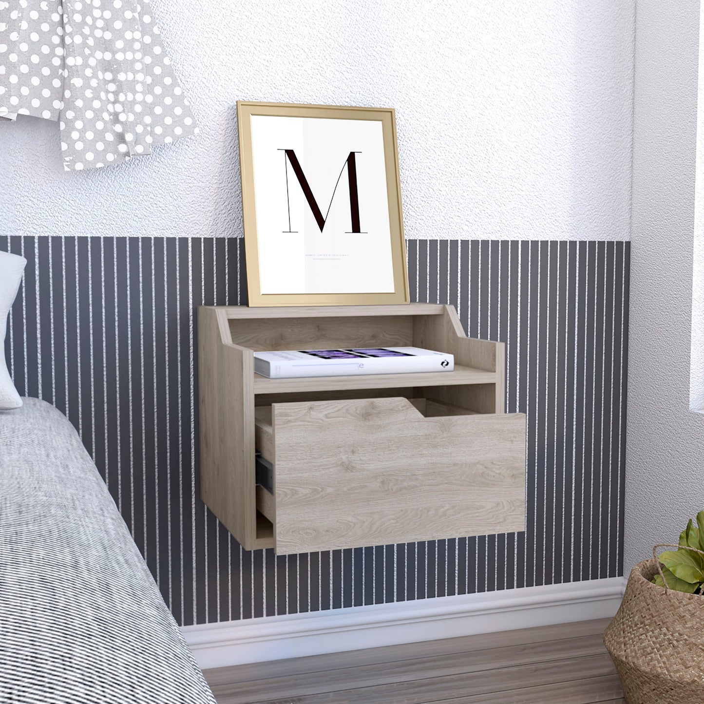 Floating oak nightstand with one drawer a framed print of M and a book
