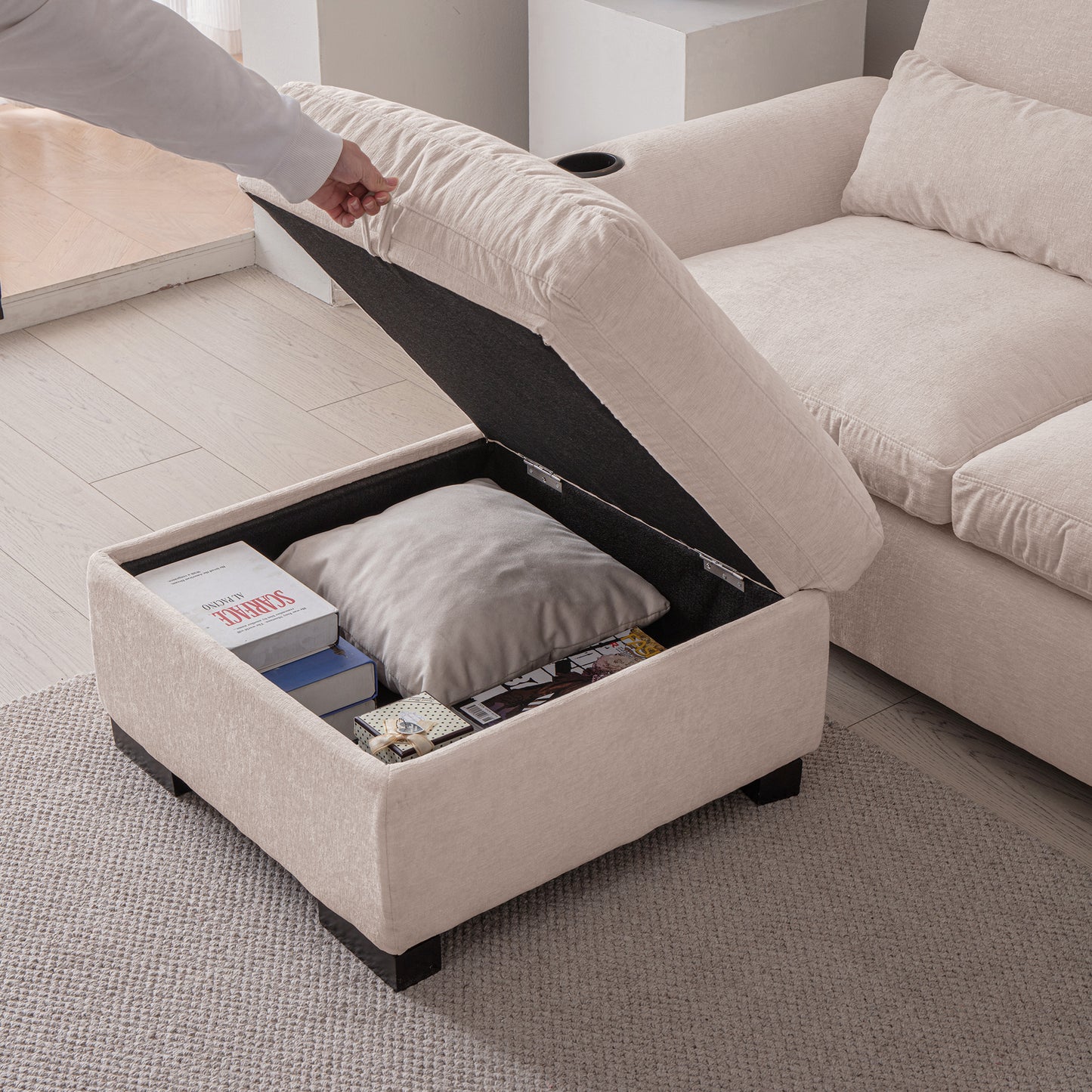 Cream upholstered ottoman with lifttop revealing storage for books and pillows