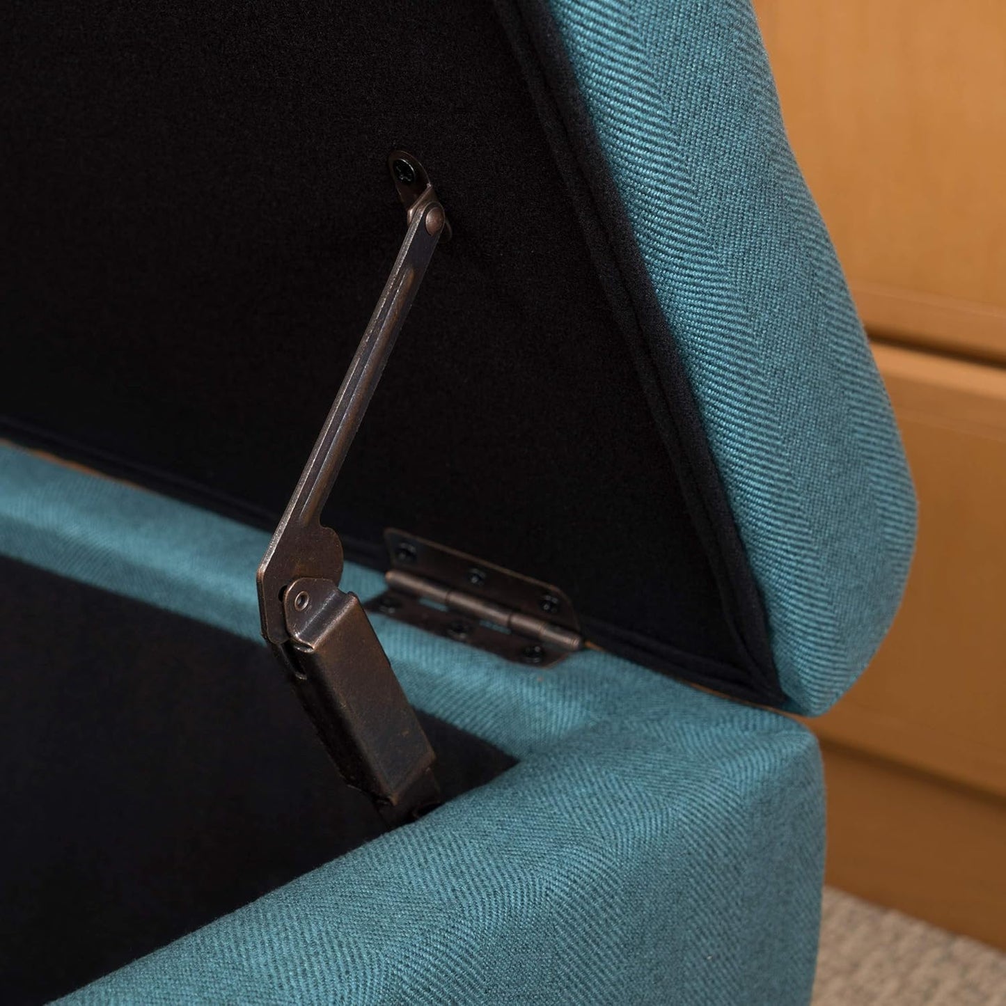 Teal upholstered storage ottoman with open lid and antique bronze hinge