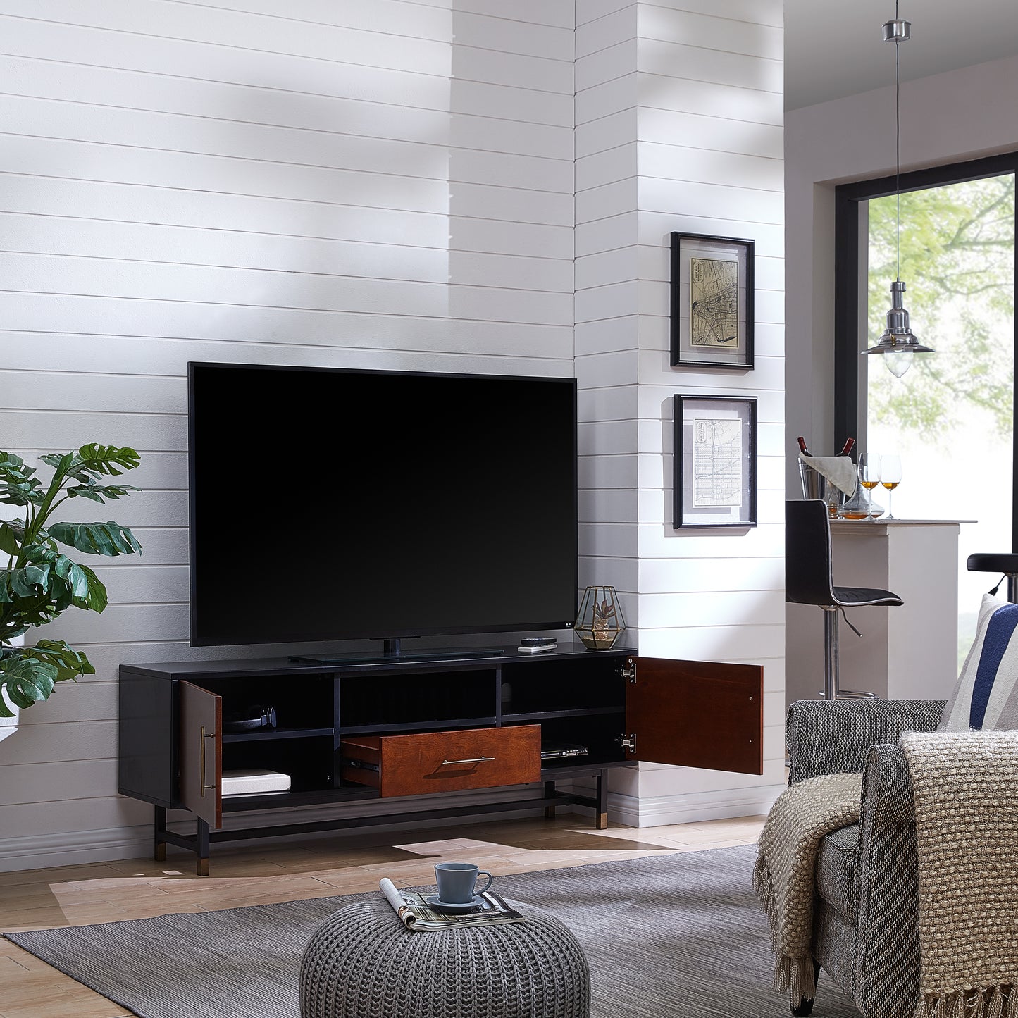 Black and wood media console with open compartments and a drawer showcasing modern living