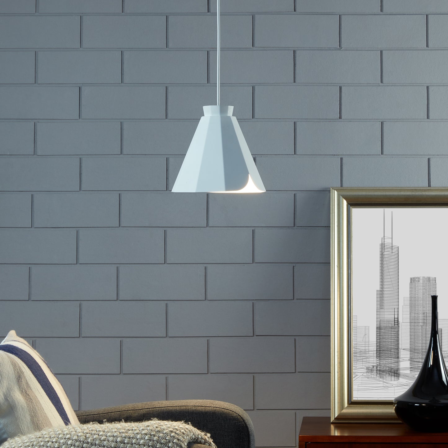 Modern white pendant light with a geometric shade casting a warm glow