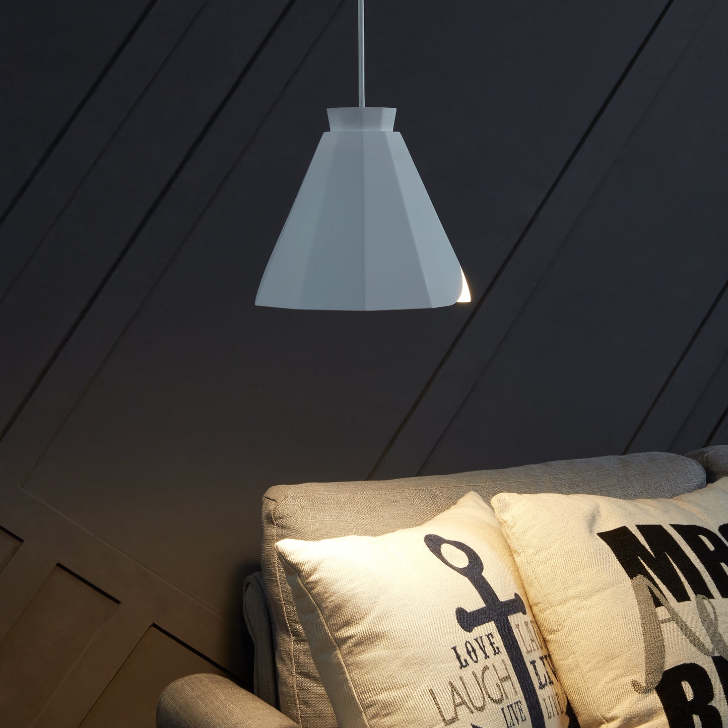 White geometric pendant light illuminating a modern living space