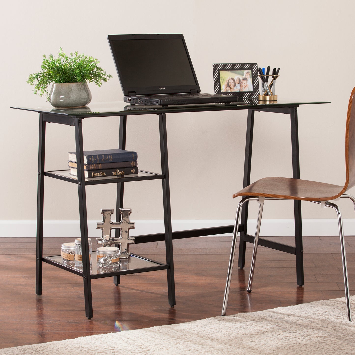 Modern glass top computer desk with black metal frame and two shelves for storage