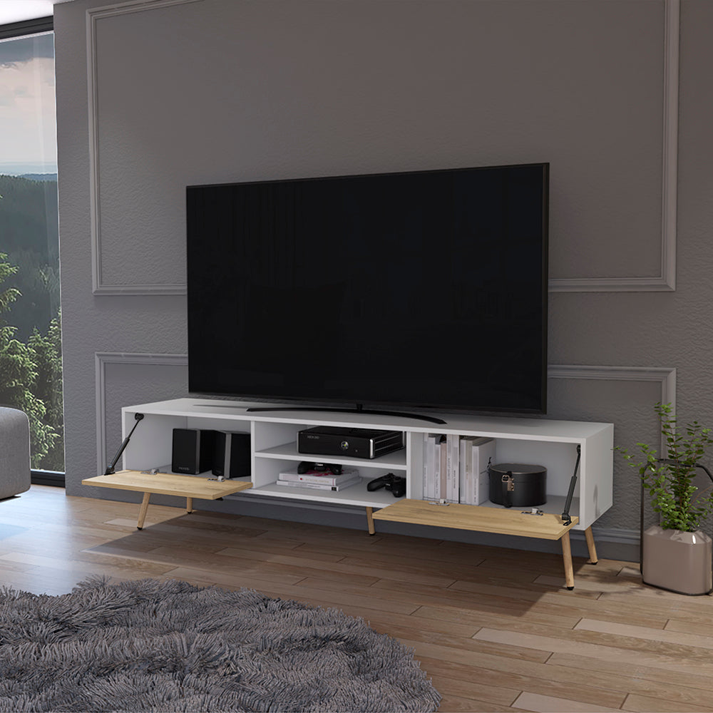 Modern white TV stand with wood accents holding a large flatscreen television and media consoles