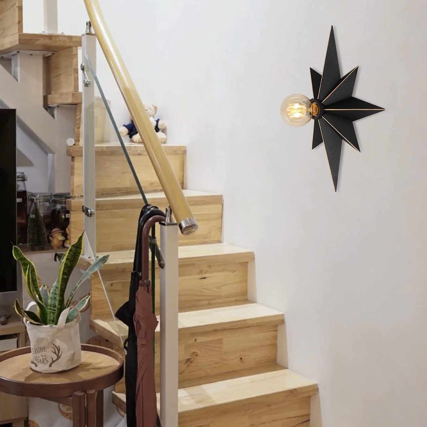 Black starburst wall sconce with exposed filament bulb for modern decor