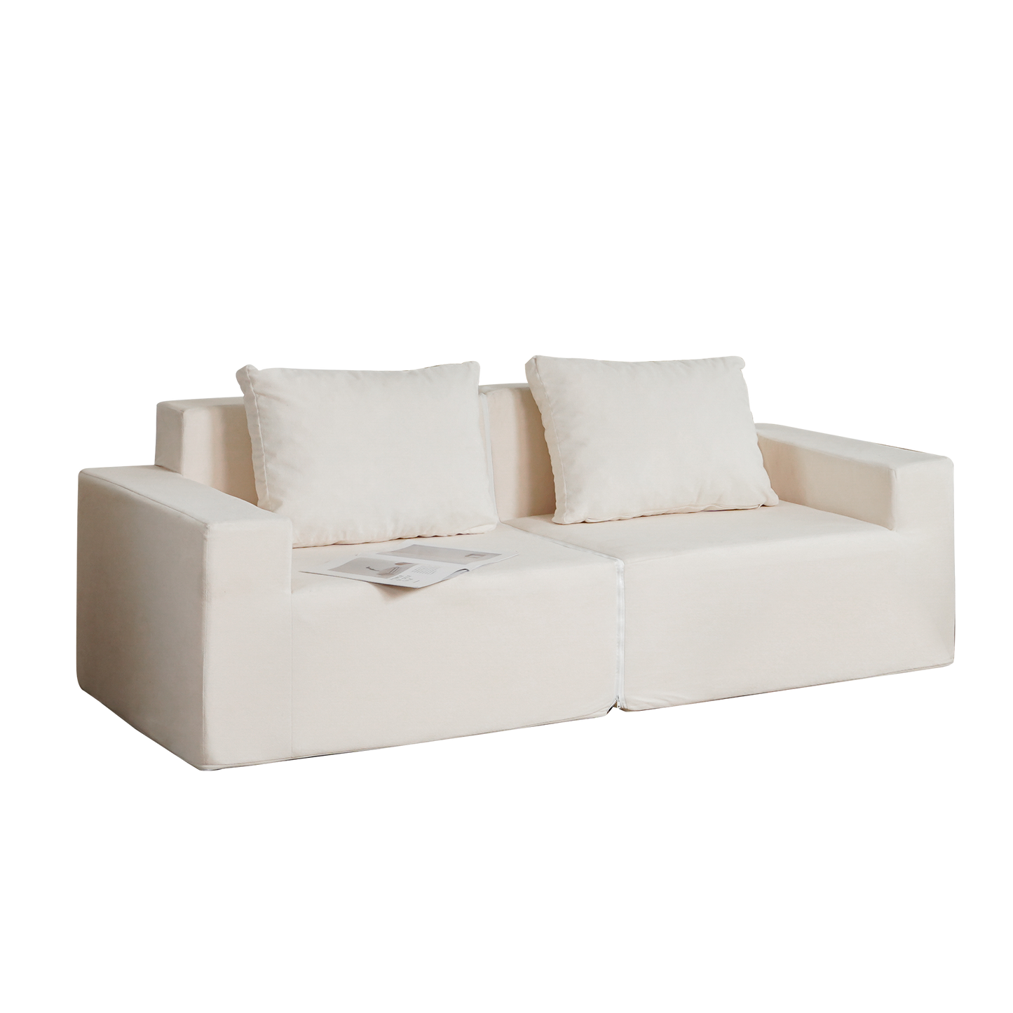 Cream linen modular sofa with two throw pillows and open magazine