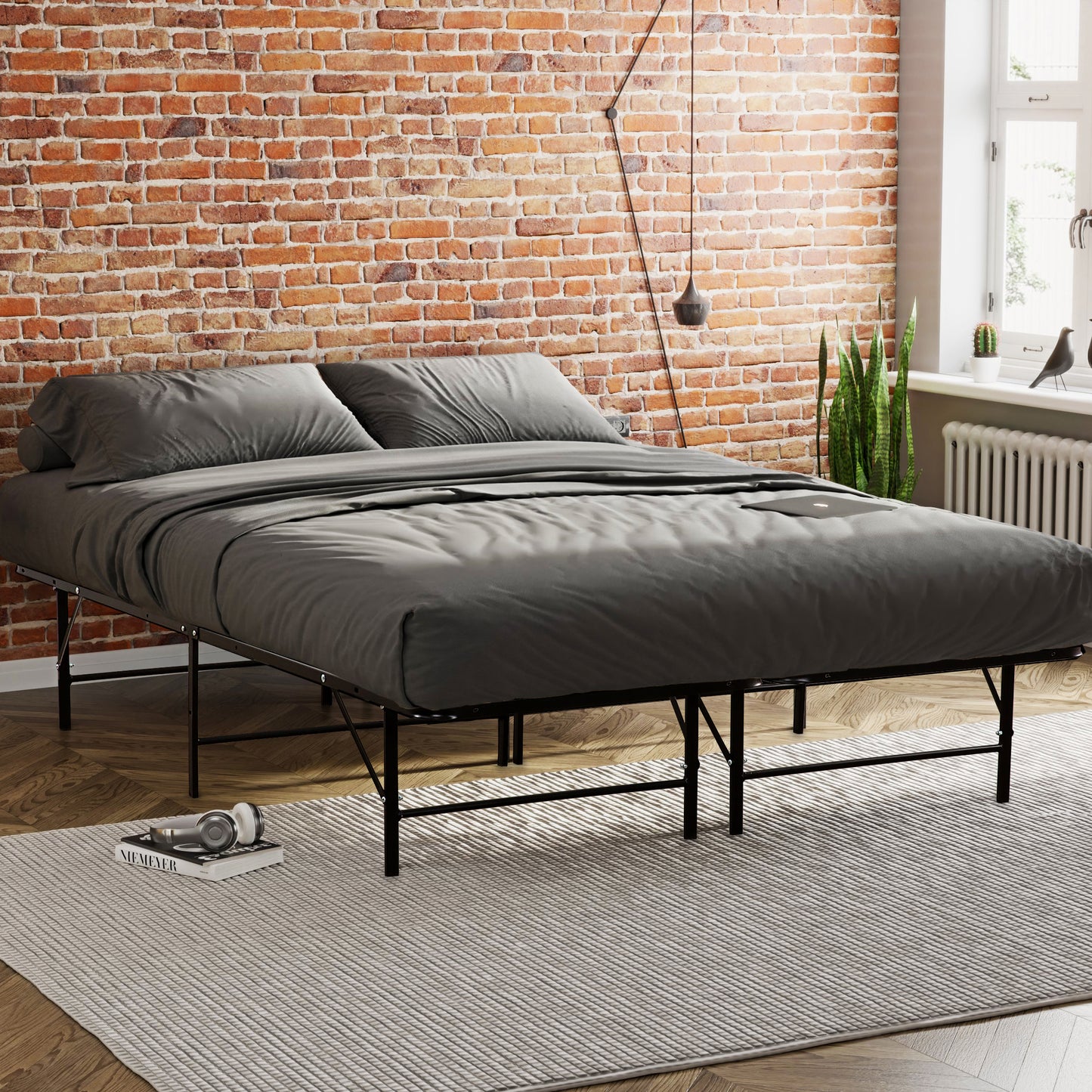 Modern platform bed frame with black metal legs and gray bedding in a loft apartment setting