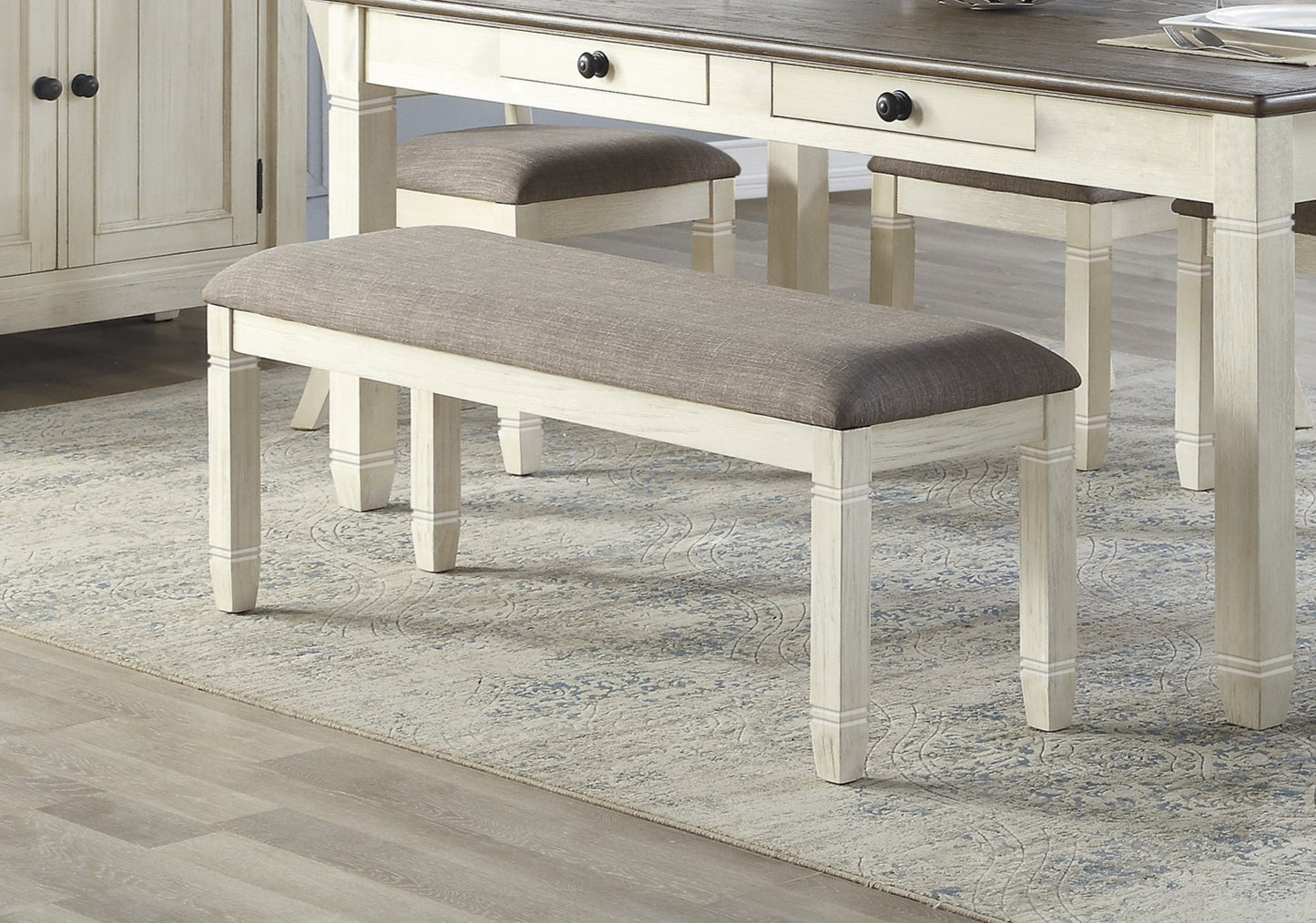 Farmhouse style dining bench with upholstered grey seat and distressed white frame