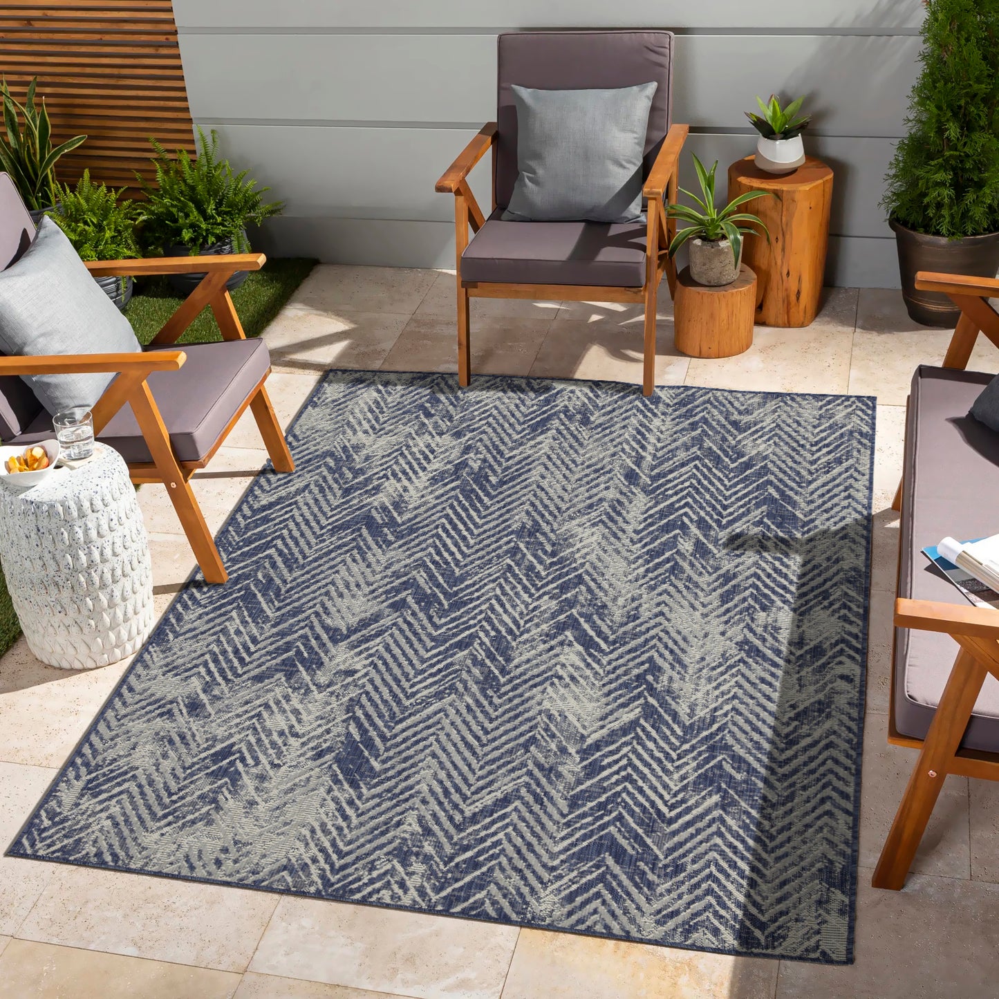 Navy blue outdoor rug with a textured herringbone pattern for patio seating areas