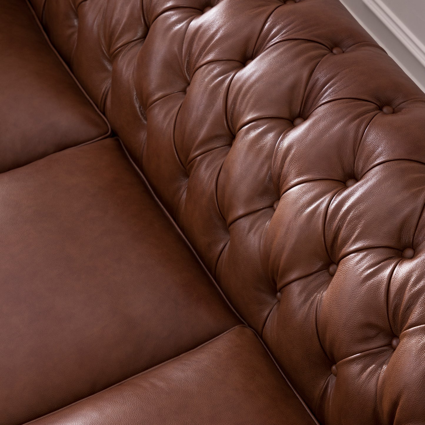 Rich brown leather Chesterfield sofa detail with button tufting