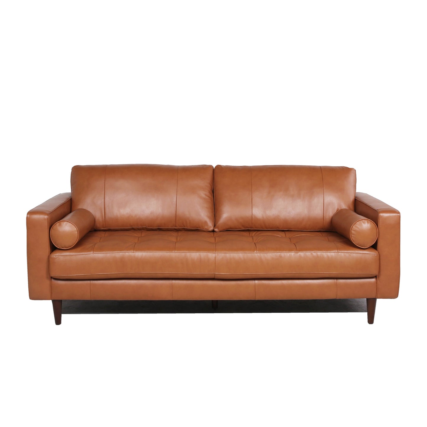 Tan leather sofa with tufted seat cushions and bolster pillows