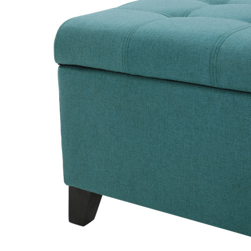 Teal fabric storage ottoman with tufted lid and dark wooden legs perfect for entryway