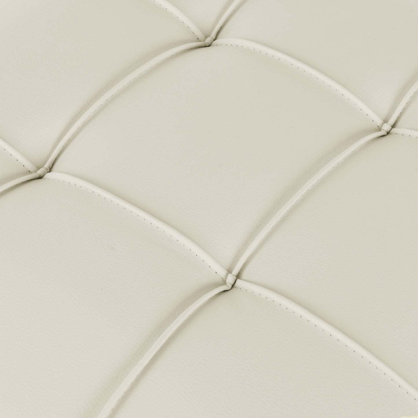 Closeup of ivory faux leather tufted upholstery fabric with diamond stitching detail