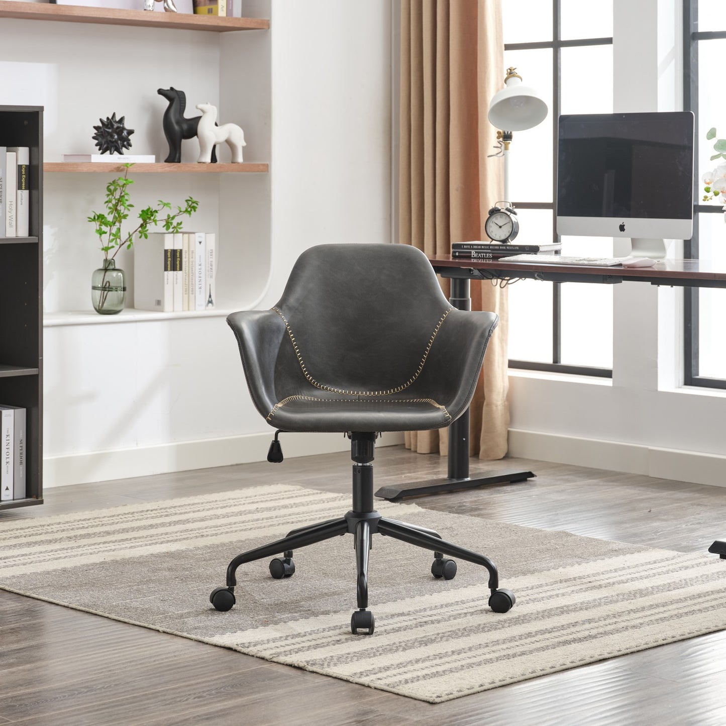 Dark gray faux leather office chair with decorative stitching and black metal base with wheels