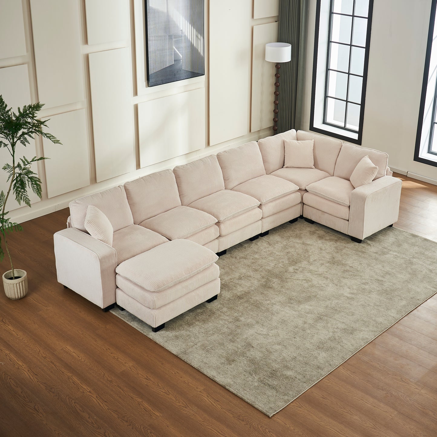 Ushaped sectional sofa in light pink corduroy with plush cushions perfect for large living rooms
