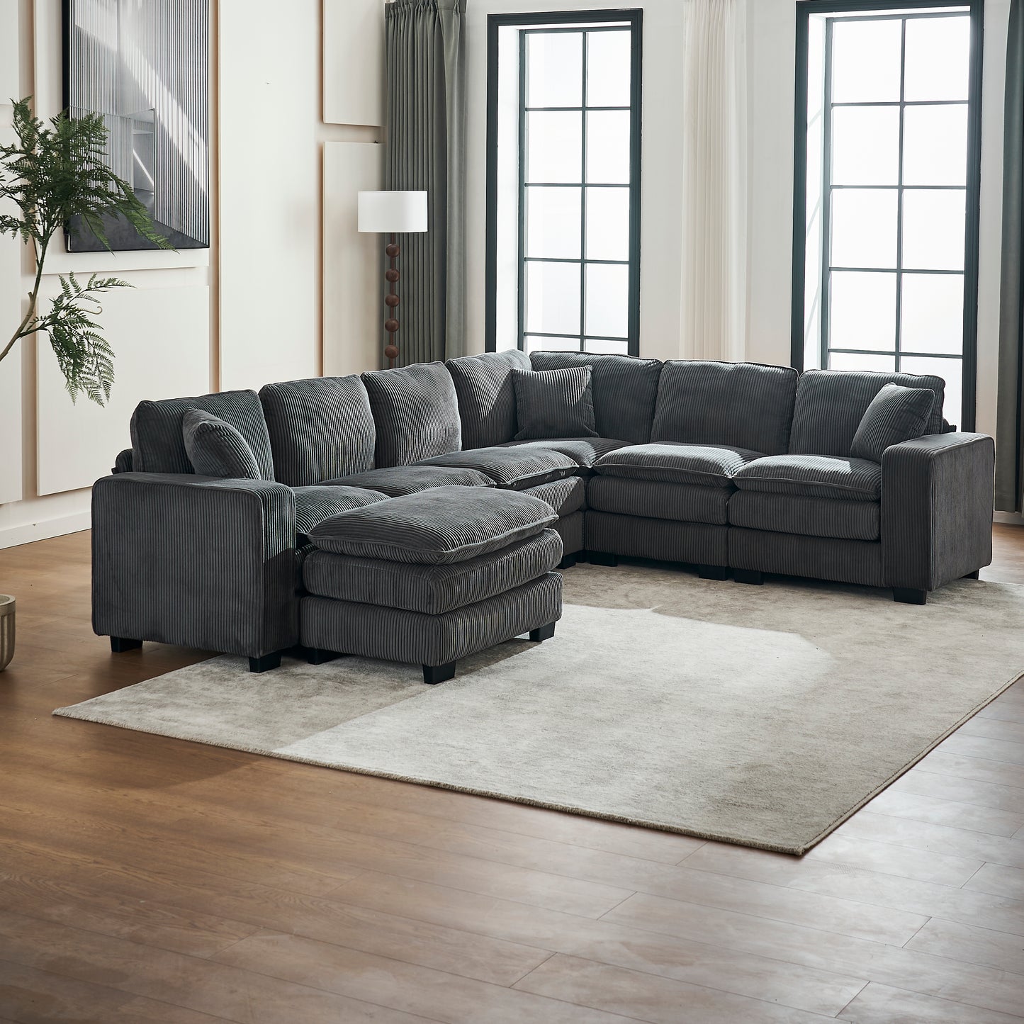 Plush charcoal corduroy sectional sofa with ottoman creating a cozy living room seating arrangement