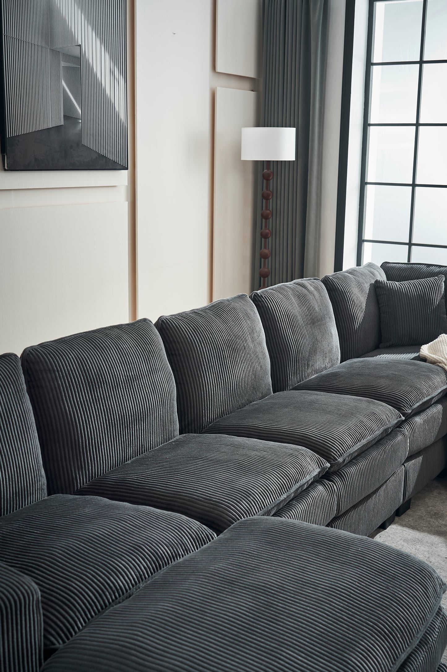 Deep charcoal sectional sofa with plush corduroy upholstery and thick cushions