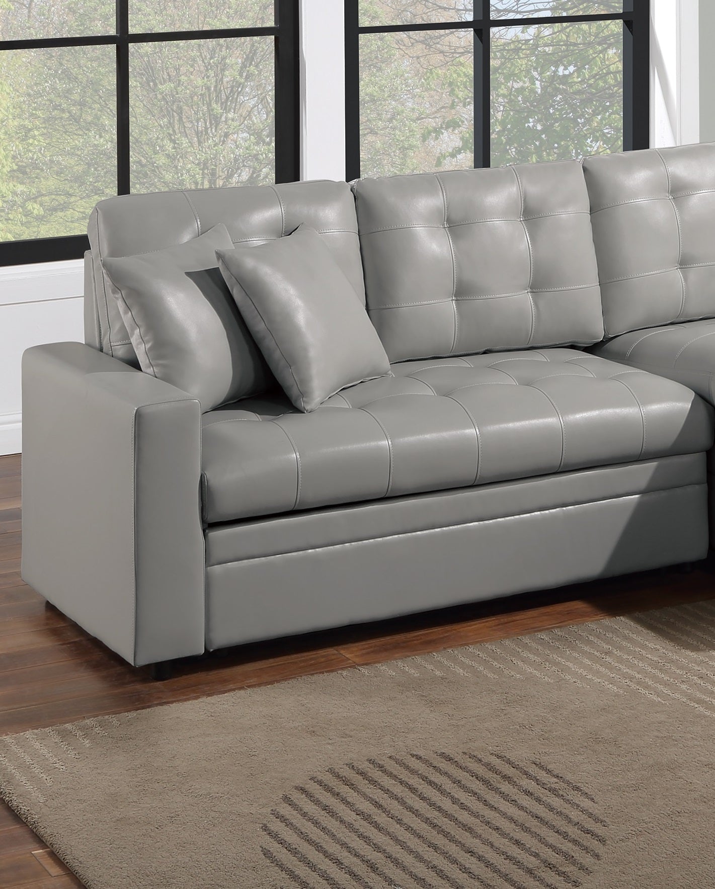 Gray faux leather sectional sofa with tufted cushions and accent pillows