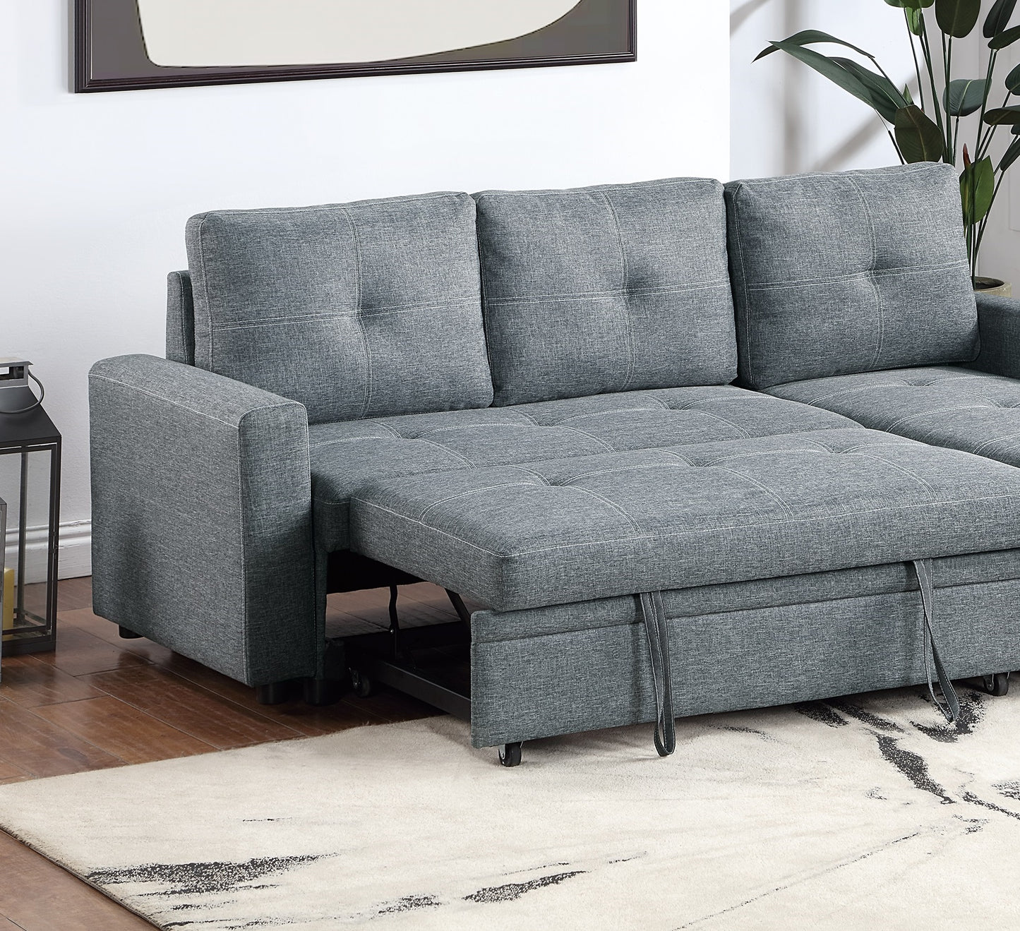 Gray sectional sofa with tufted cushions and pullout bed feature
