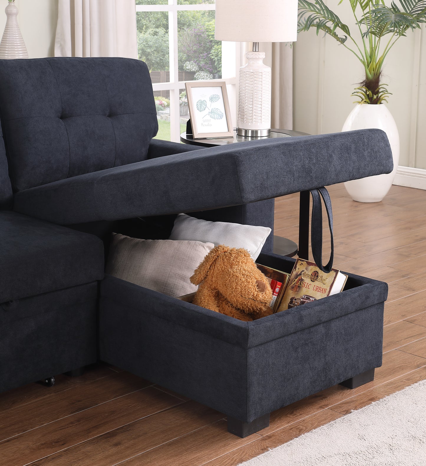 Dark blue fabric sectional sofa with hidden storage compartment open revealing pillows and books