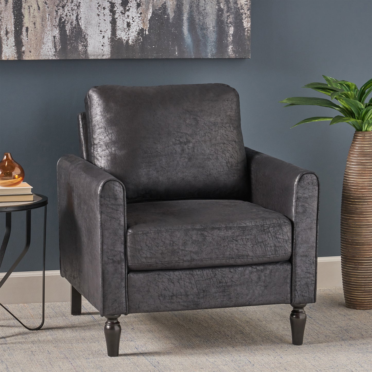 Dark gray faux leather accent chair with plush cushions and tapered legs