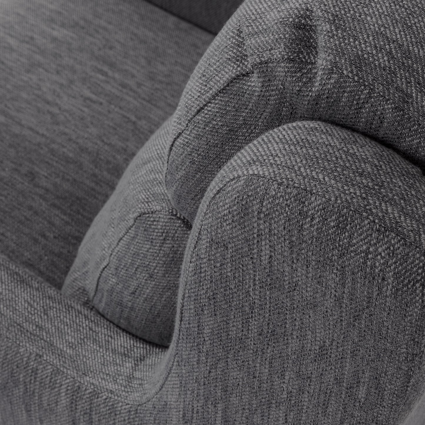 Closeup of a textured charcoal gray woven fabric armchair detail