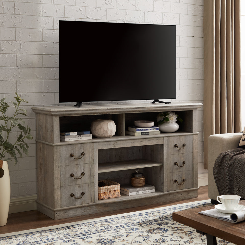 Rustic grey wash TV stand with drawers and open shelves holding decor