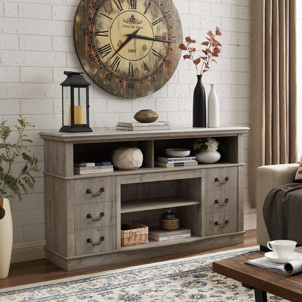 Rustic gray wood TV stand with three drawers on the left open shelves and decorative accents