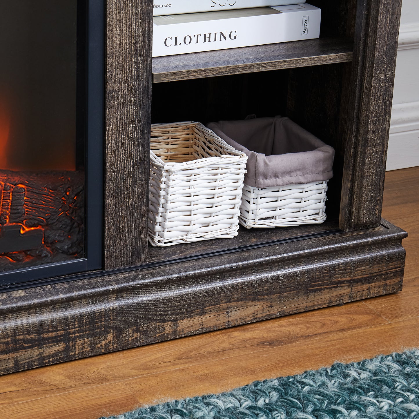 Dark wood fireplace media console with two woven baskets and books on shelf