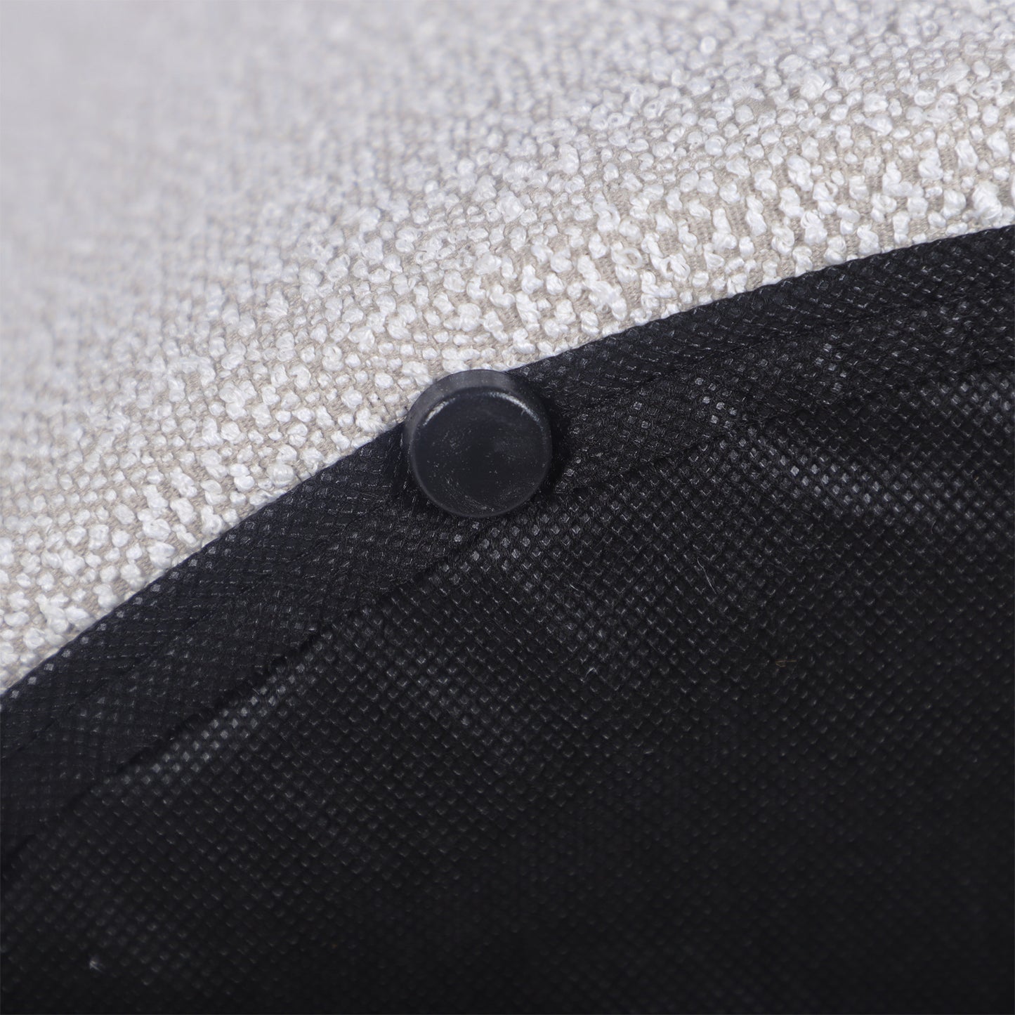 Closeup of a textured light grey fabric with a black plastic foot for furniture stability