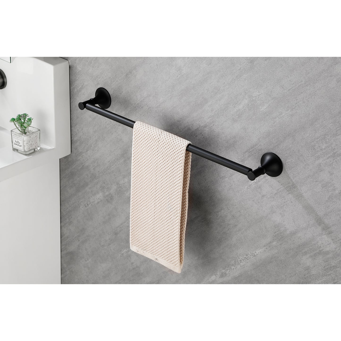 Black metal towel bar mounted on a grey tiled wall holding a cream textured towel