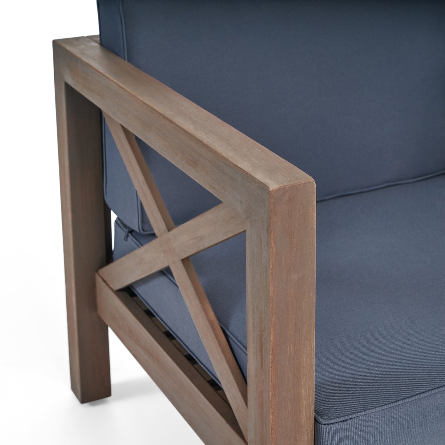 Closeup of a wooden armchair armrest with xdesign featuring navy blue cushion