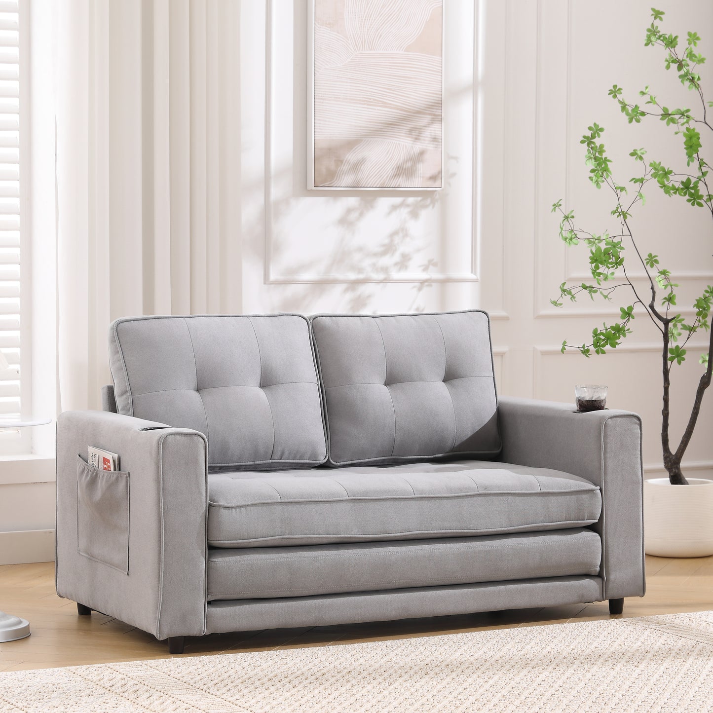 Grey upholstered loveseat with tufted cushions and side storage pocket