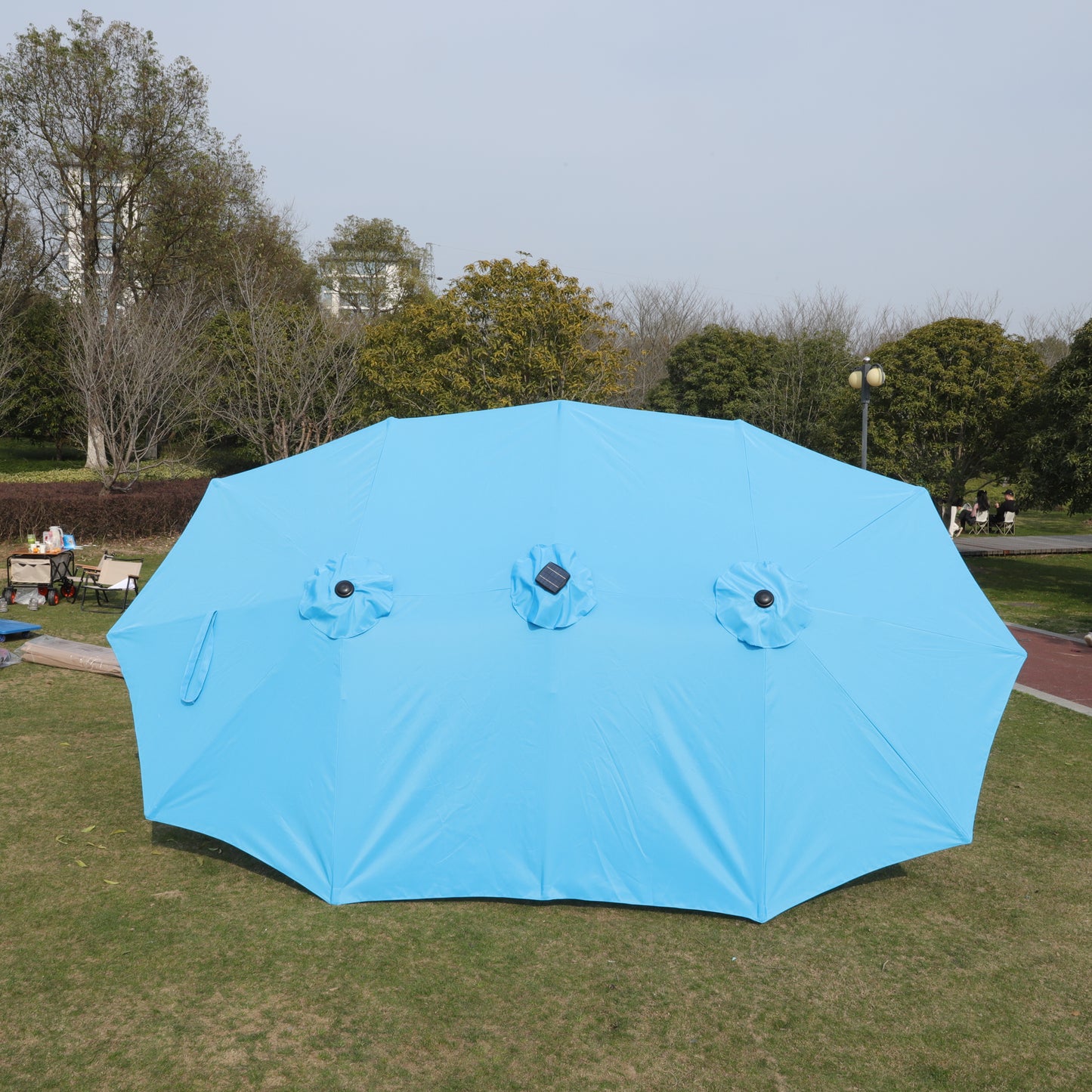 Large light blue patio umbrella with three solar panels ideal for outdoor relaxation