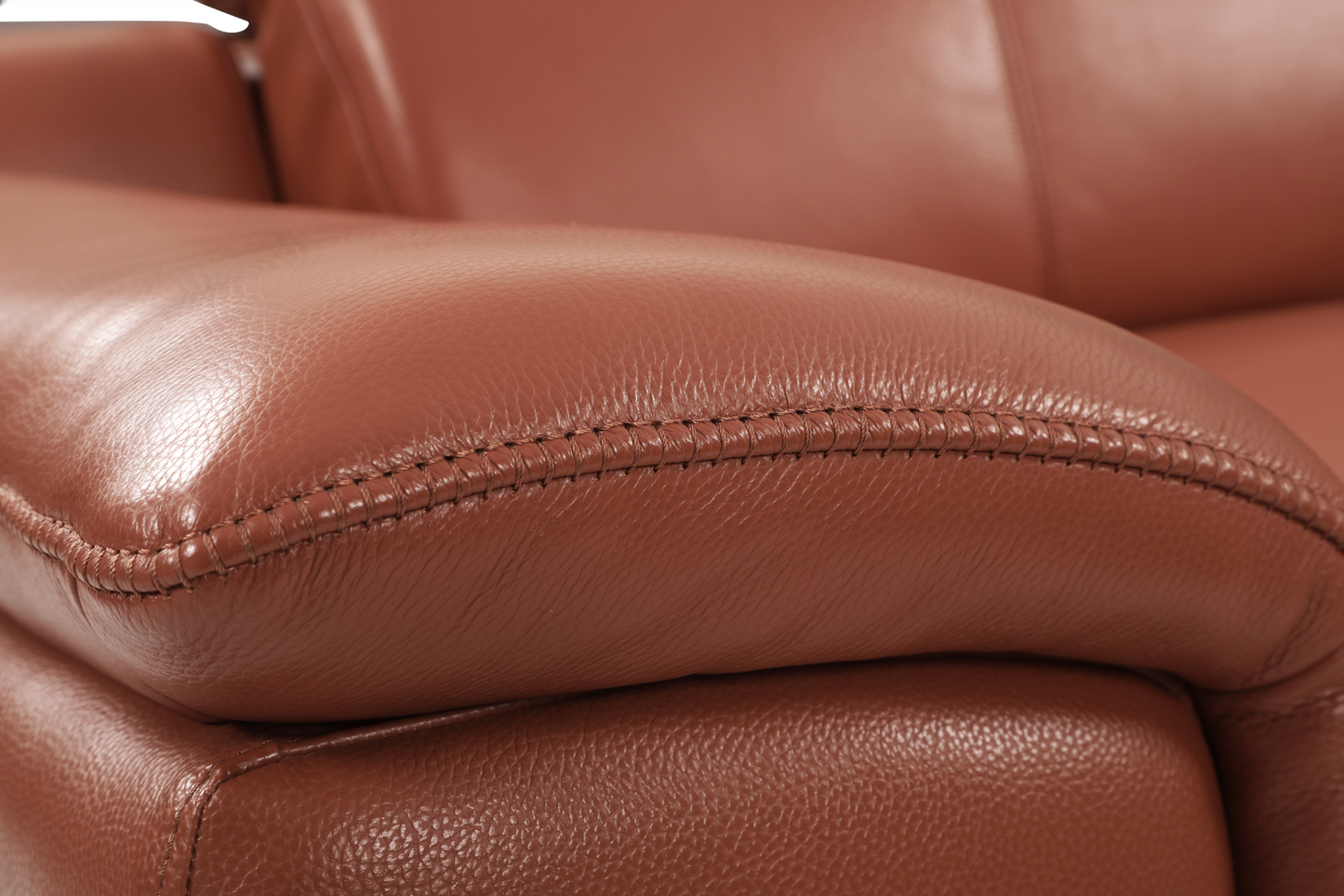 Brown leather armchair armrest detail with stitching