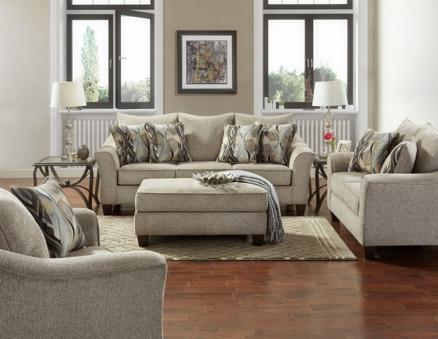 Beige upholstered sofa with abstract patterned throw pillows and ottoman