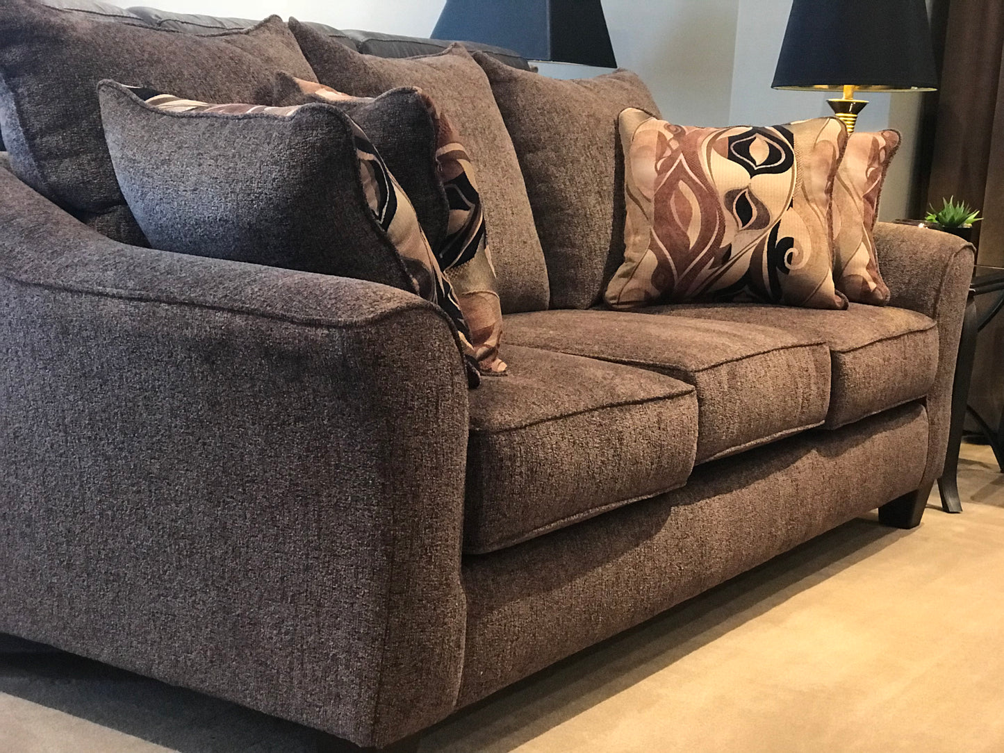 Plush brown textured fabric sofa with ornate patterned throw pillows for living room comfort