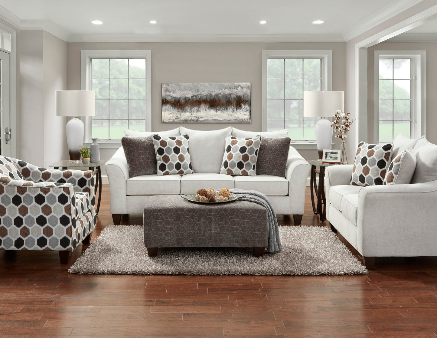 White sofa with patterned accent pillows and a hexagonal armchair